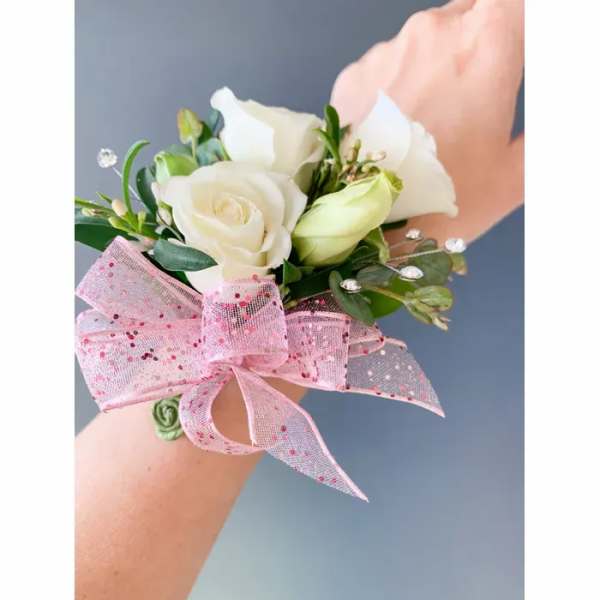 White rose wrist corsage with a pink ribbon bow