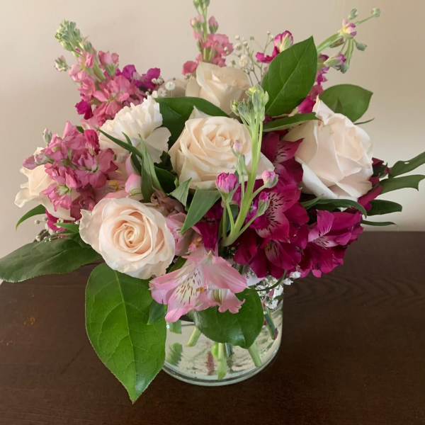 Bouquet of cream roses and pink flowers in a clear glass vase