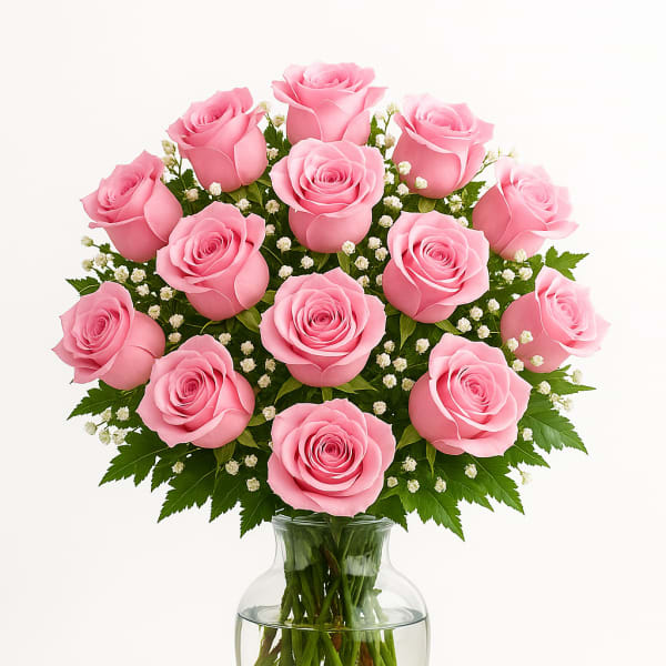 Pink roses arranged in a clear glass vase with small white filler flowers