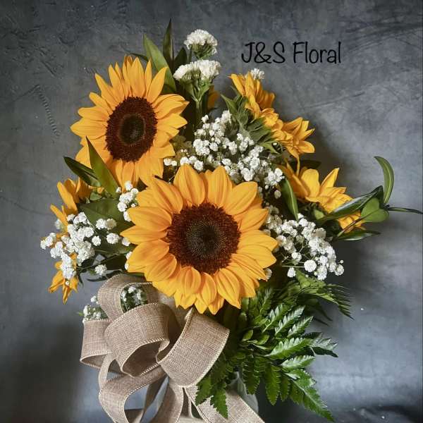 Sunflower bouquet in a glass vase with baby's breath and a burlap ribbon