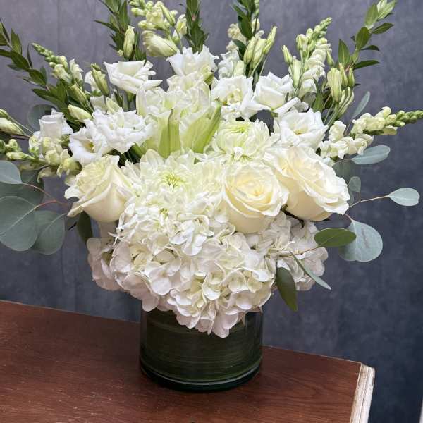 White floral arrangement in a dark green vase