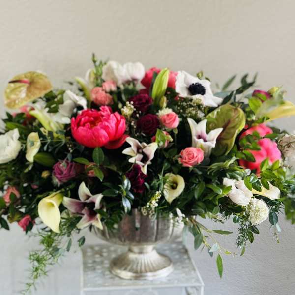 Large mixed floral arrangement in a silver urn vase