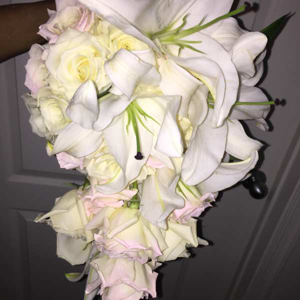 White lilies and pale roses in a cascading bouquet