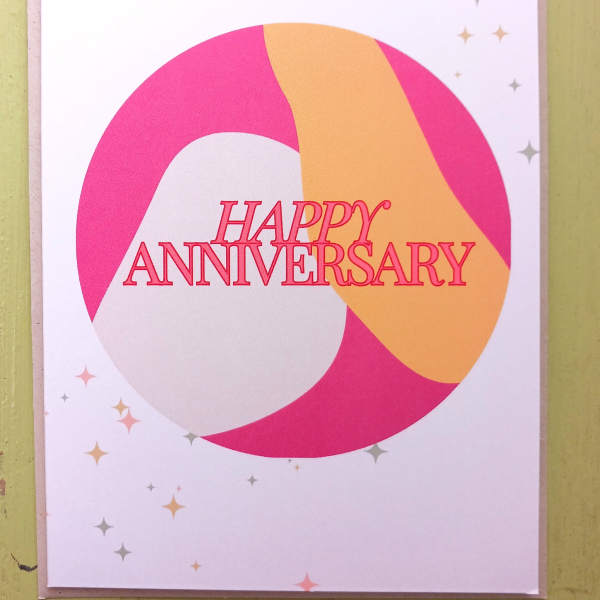 Happy anniversary greeting card with pink and peach abstract circle design and small star accents
