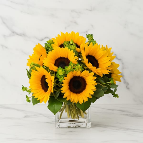 Bouquet of yellow sunflowers in a clear glass vase
