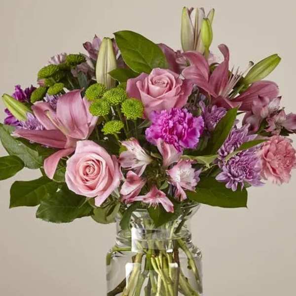 Pink and purple mixed bouquet in a clear glass vase