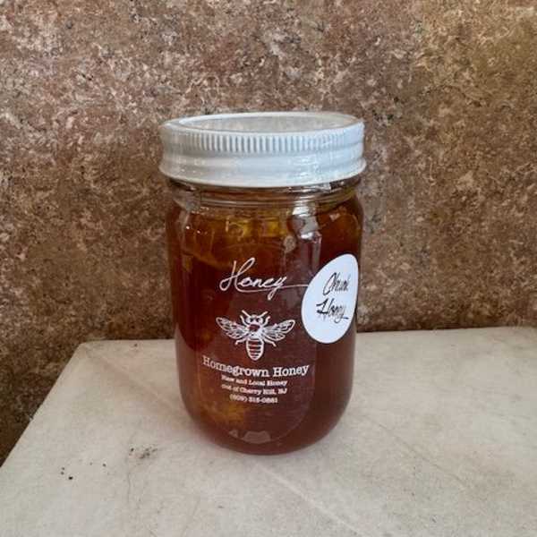 Jar of honey with a silver lid on a countertop