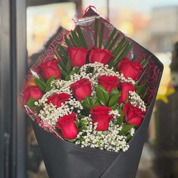 Bouquet of red roses with baby's breath wrapped in black paper