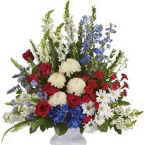 Red, white, and blue floral arrangement in a white vase