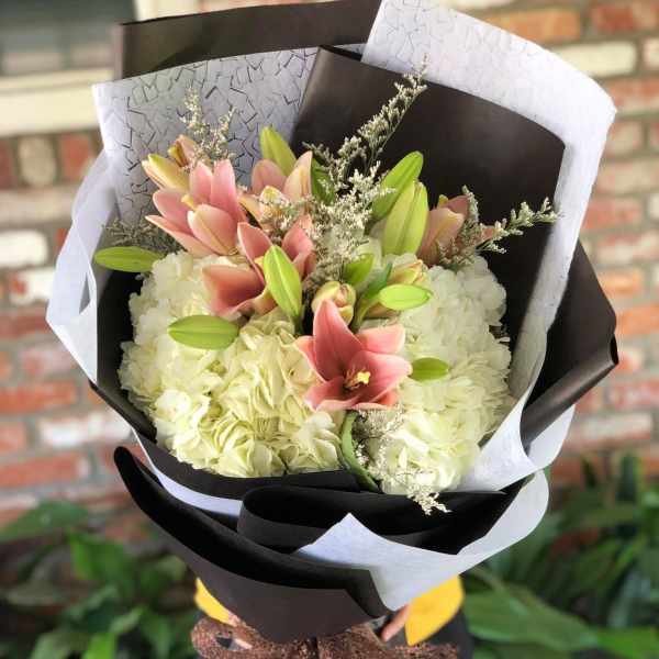 Bouquet of pink lilies and white hydrangeas wrapped in black and white paper