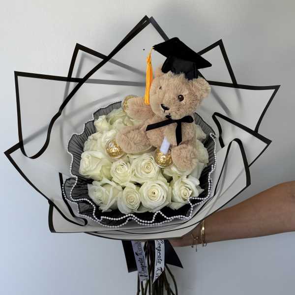 White rose bouquet with a teddy bear in a graduation cap