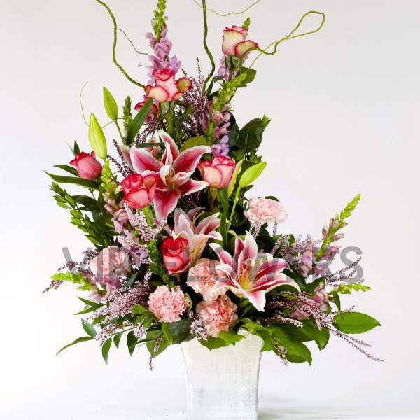 Tall pink and white floral arrangement in a white vase