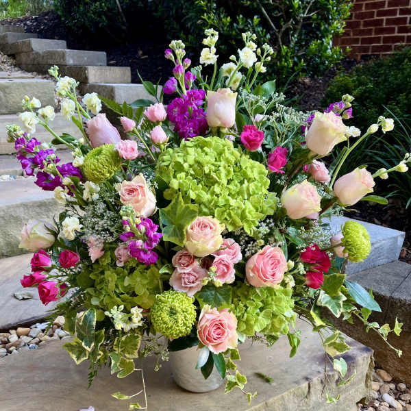 Large mixed bouquet in a white vase with pink roses and green hydrangeas