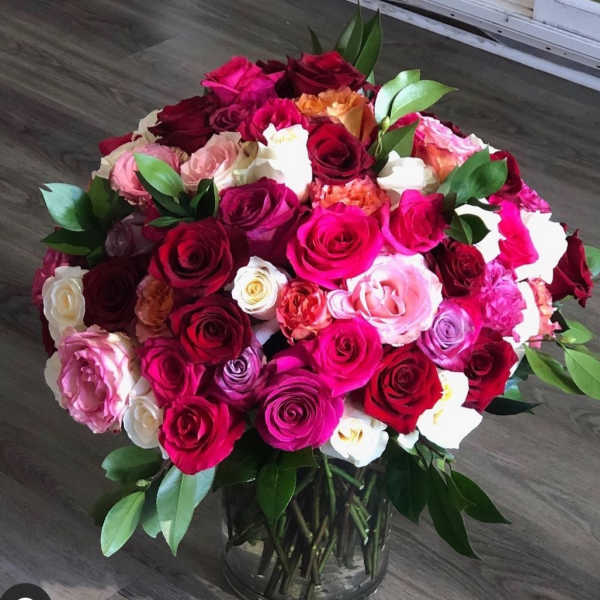 Large bouquet of multicolored roses in a glass vase
