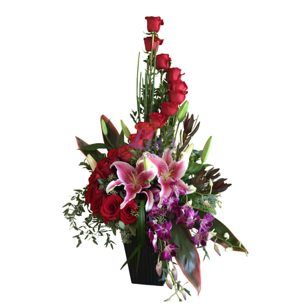 Tall arrangement of red roses and pink lilies in a black vase