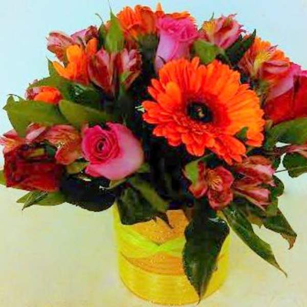 Bouquet of orange and pink flowers in a yellow vase