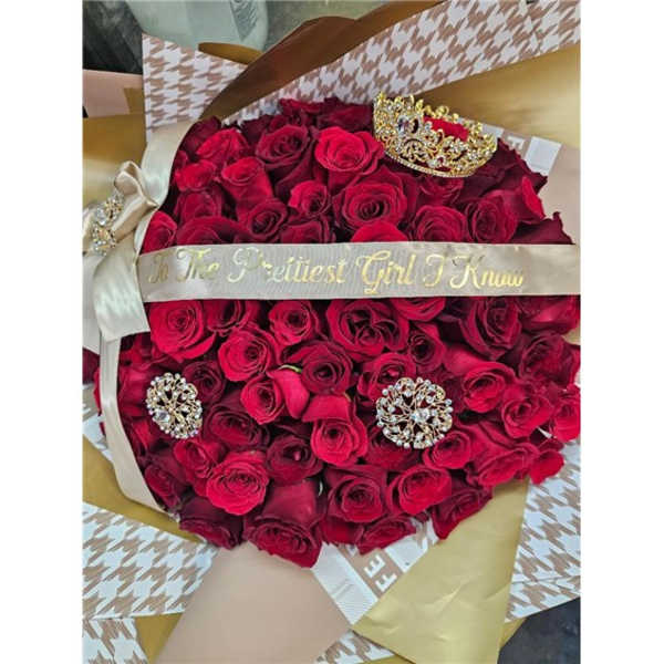 Bouquet of red roses with a decorative ribbon and jeweled crown accents