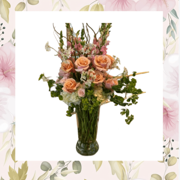 Peach roses and pink flowers arranged in a glass vase