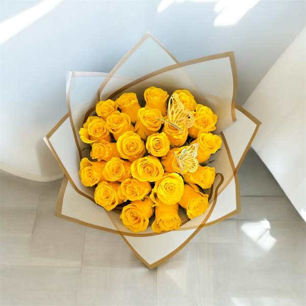 Bouquet of yellow roses wrapped in white and brown paper