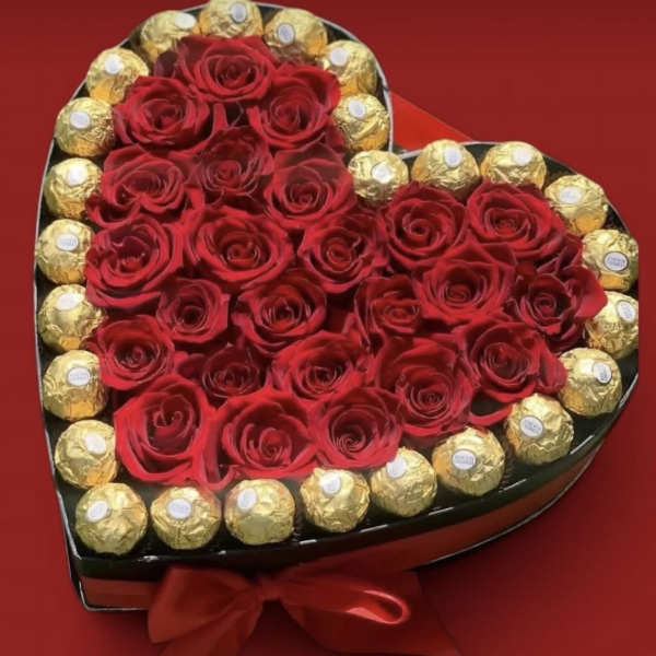 Heart-shaped box of red roses surrounded by gold-wrapped chocolates