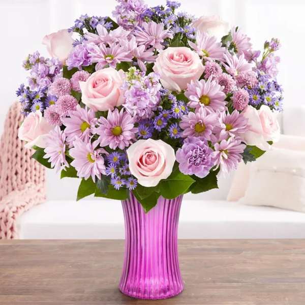 Pink and lavender bouquet in a purple glass vase