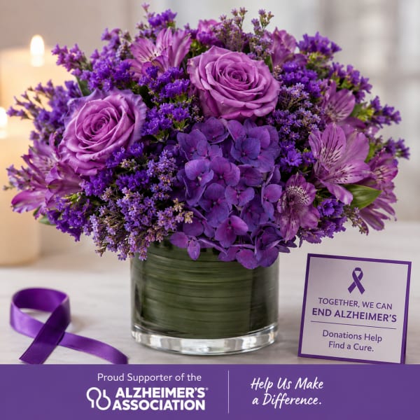 Purple floral arrangement in a glass vase with an Alzheimer’s awareness card and ribbon