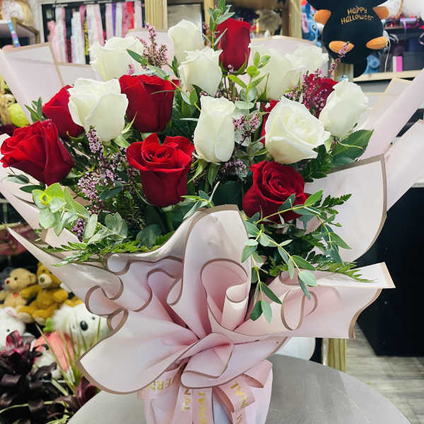 Bouquet of red and white roses wrapped in pink paper