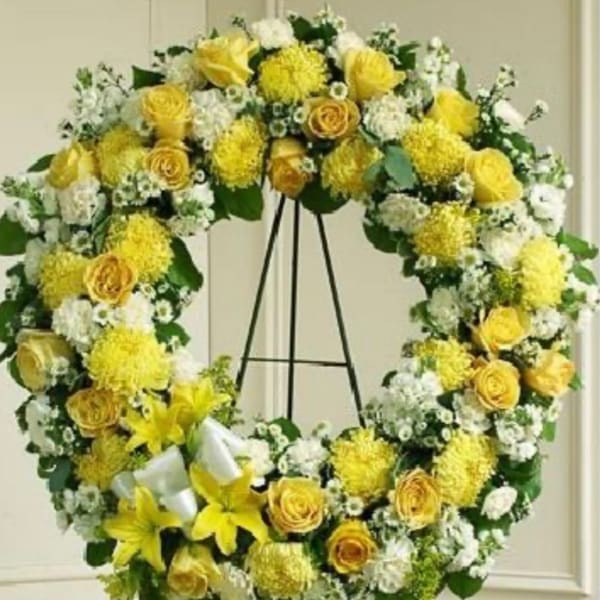 Yellow and white floral wreath on a stand