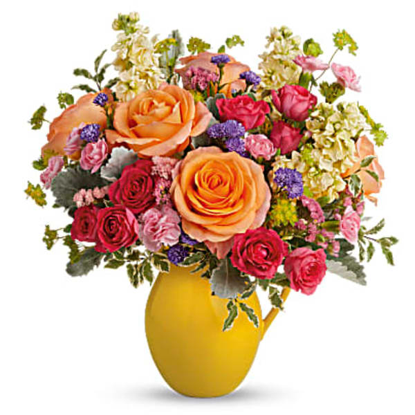 Mixed bouquet of orange and pink roses in a yellow vase