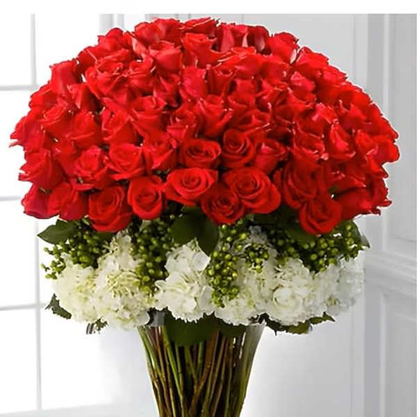 Large bouquet of red roses with white flowers in a clear glass vase