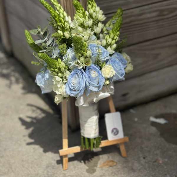 Blue roses and white flowers in a hand-tied bouquet