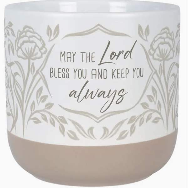 White candle jar with floral pattern and blessing text