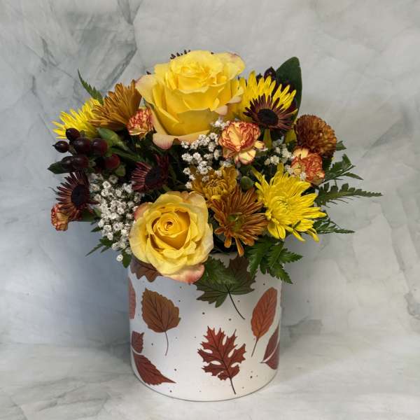 Yellow roses and mixed chrysanthemums in a leaf-patterned box