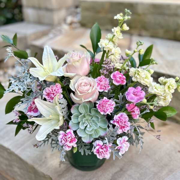 Pink roses and carnations with white lilies in a green vase