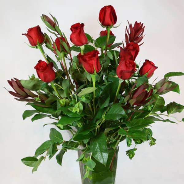 Red roses arranged in a clear glass vase