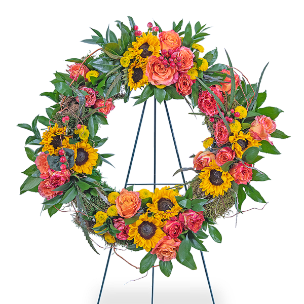 Circular floral wreath with sunflowers, orange roses, and pink blooms