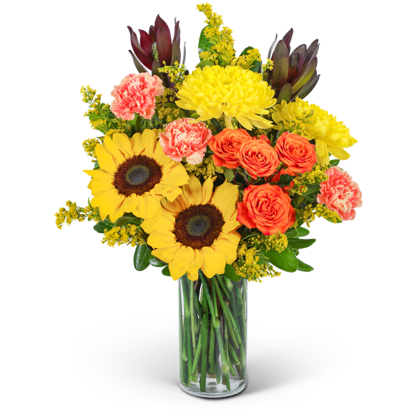 Bouquet of sunflowers, orange roses, and pink carnations in a glass vase