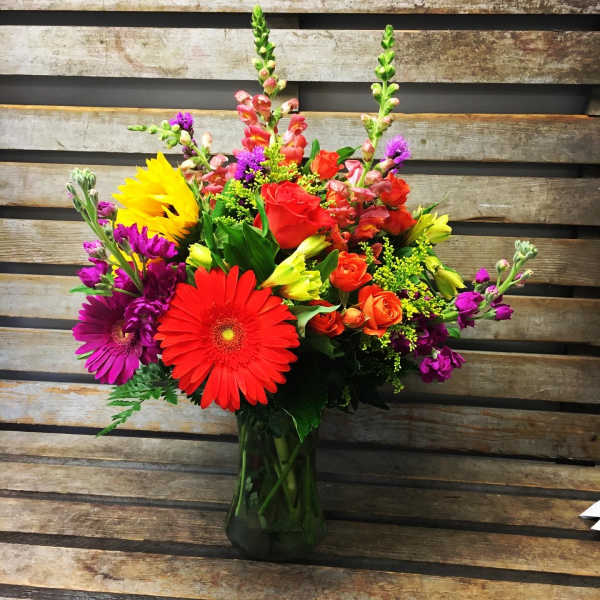 Colorful mixed bouquet in a dark glass vase