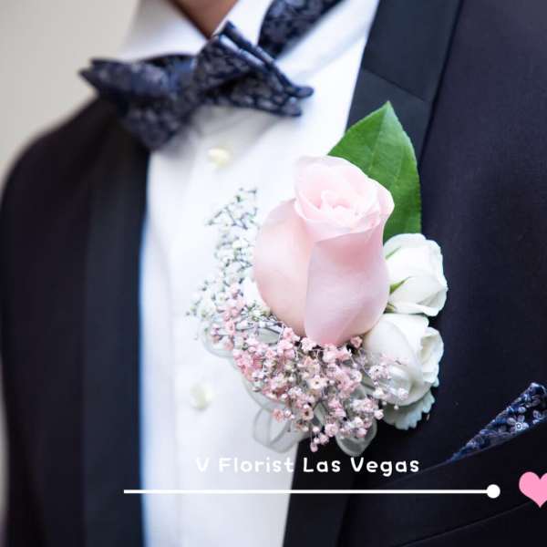 Pink and white boutonniere on a black suit jacket