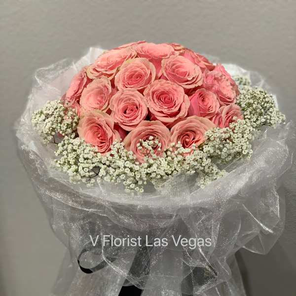 Pink rose bouquet with white baby's breath wrapped in sheer fabric