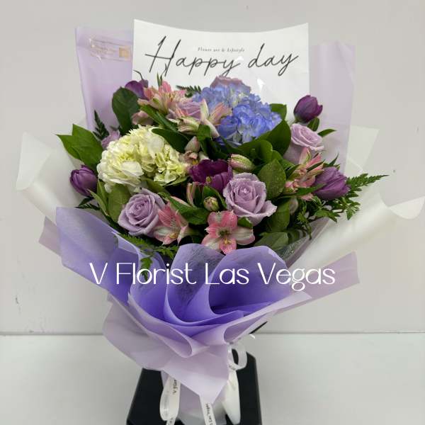 Bouquet of lavender and blue flowers wrapped in purple paper