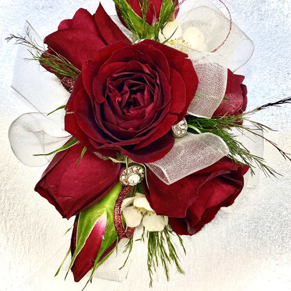 Red rose corsage with white ribbon and small white accents