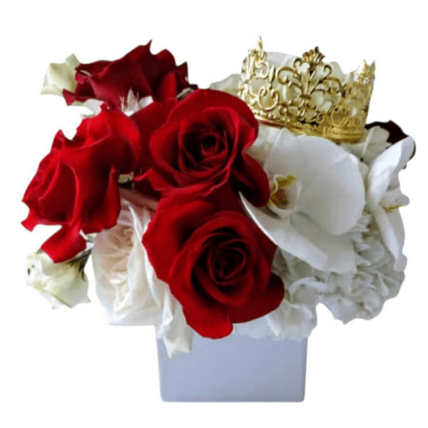 Red and white roses arranged in a white vase with a gold crown