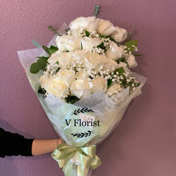 Bouquet of white roses with baby's breath wrapped in pale paper