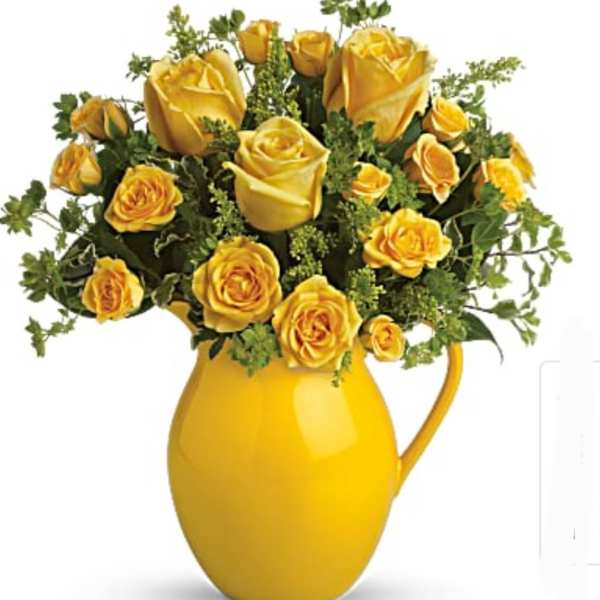 Yellow roses arranged in a yellow pitcher vase