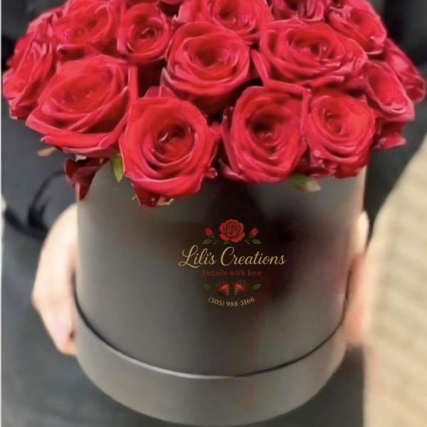 Red roses arranged in a black round box