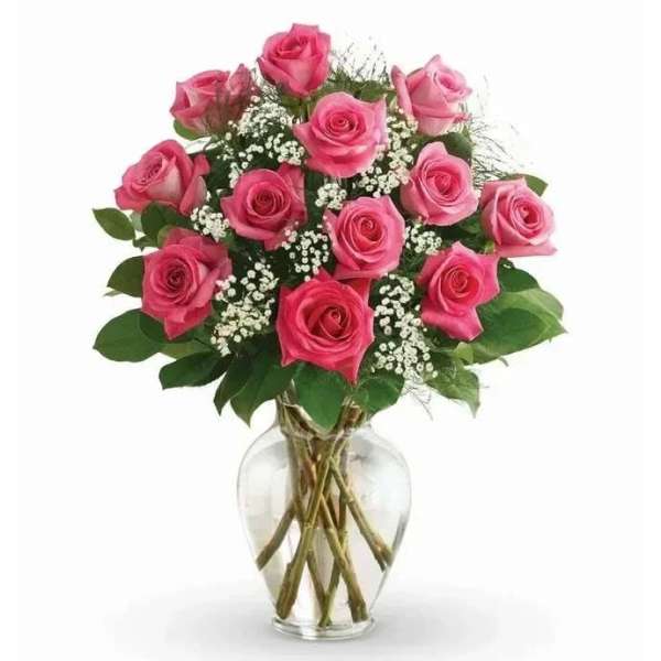 Pink roses arranged in a clear glass vase with baby's breath