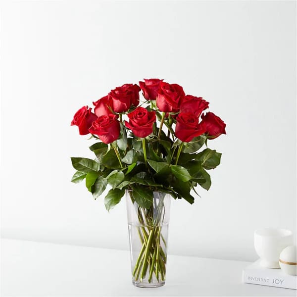 Red roses arranged in a clear glass vase