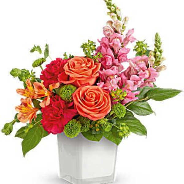 Mixed bouquet of roses, alstroemeria, and snapdragons in a white vase