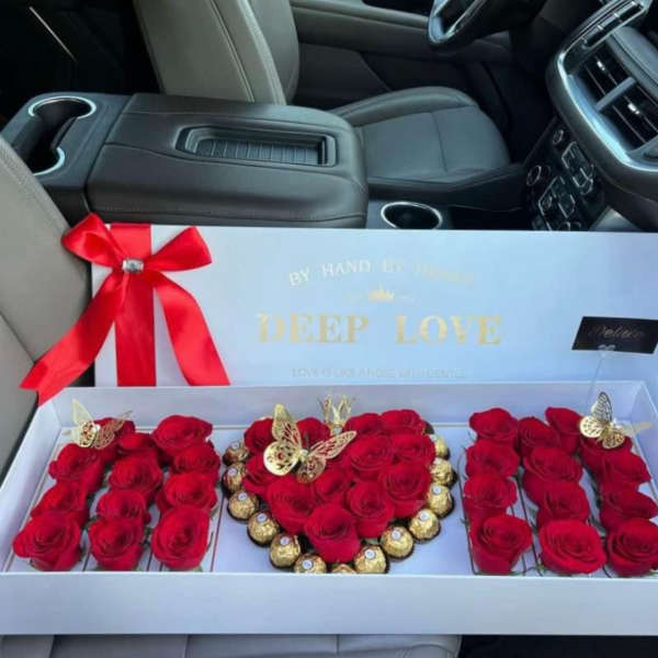 Red roses and chocolates arranged in a gift box with a ribbon